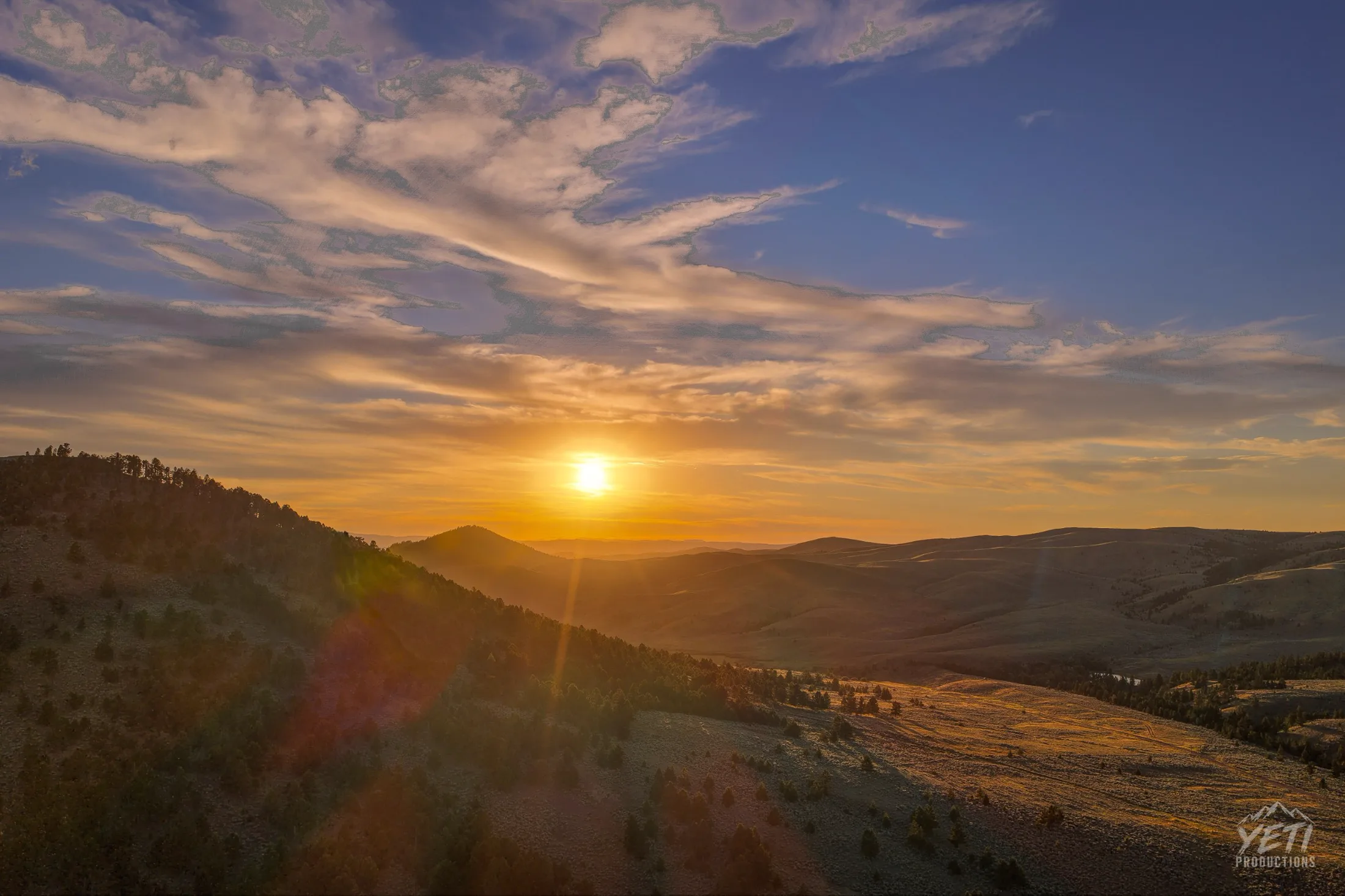 Golden sunset over forested Montana hills